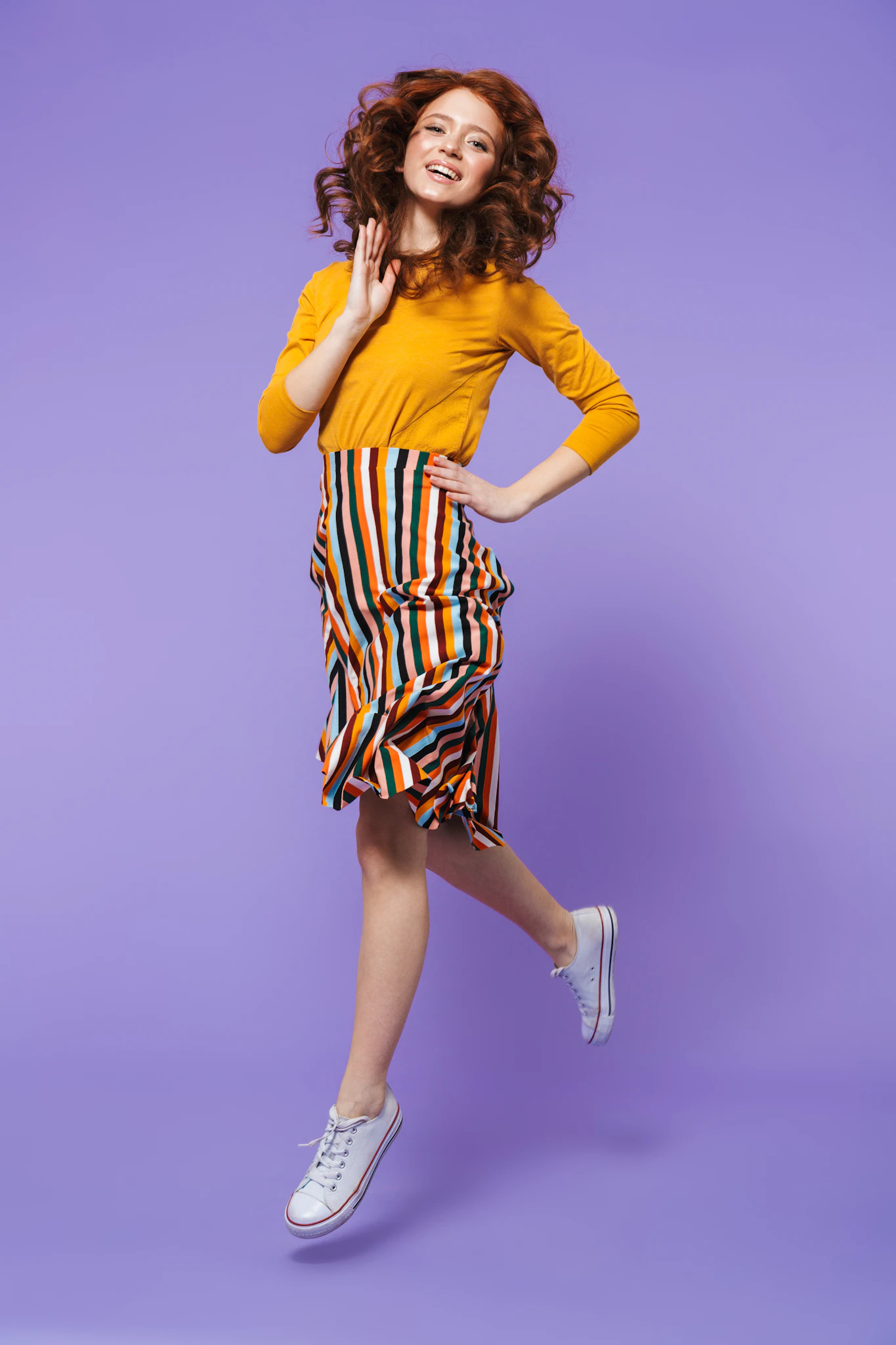 a woman in a yellow shirt and striped skirt
